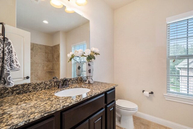 full bath with vanity, toilet, a wealth of natural light, and baseboards