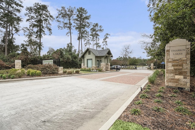 view of street with a gated entry and curbs