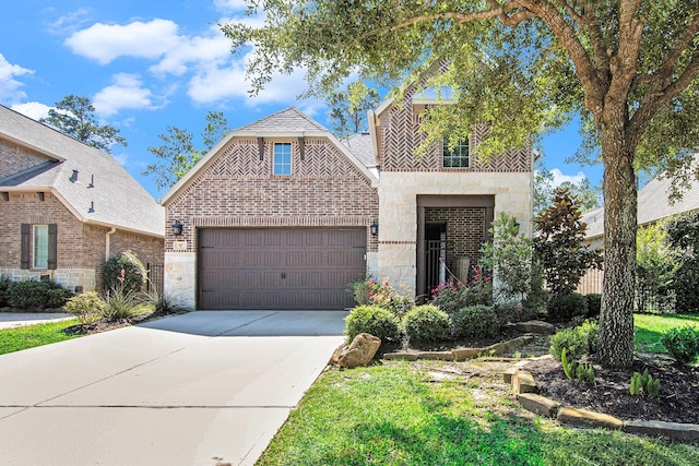 42 Sundown Ridge Pl, Tomball, TX 77375 - view of front facade with stone siding, driveway, a garage, and brick siding