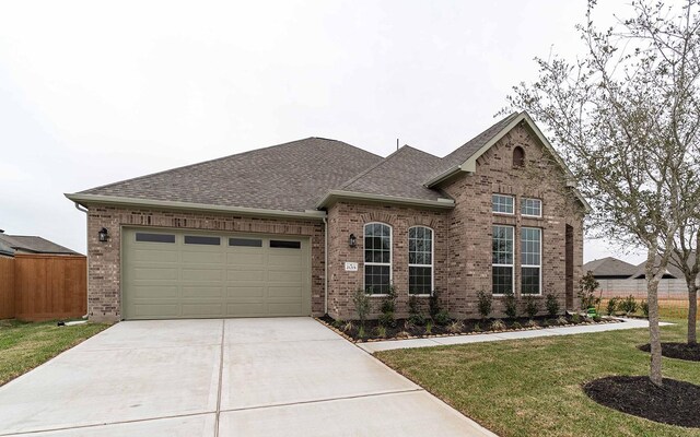 21215 Brook Tide Ln, Cypress, TX 77433 - view of front of home featuring brick siding, a garage, concrete driveway, a front yard, and roof with shingles
