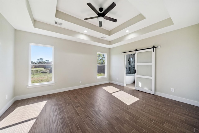 237 Crestview Dr, West Columbia, TX 77486 - unfurnished bedroom with baseboards, visible vents, a barn door, and a raised ceiling