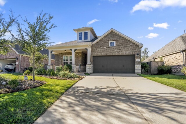 craftsman-style house featuring concrete driveway, brick siding, a front lawn, and fence