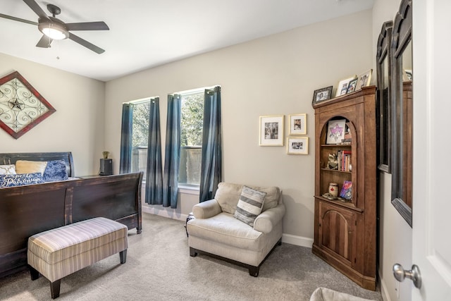 bedroom featuring light colored carpet, baseboards, and a ceiling fan