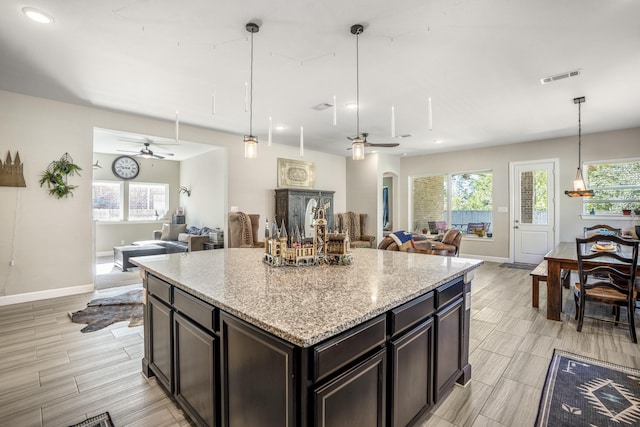 kitchen with plenty of natural light, baseboards, visible vents, ceiling fan, and open floor plan
