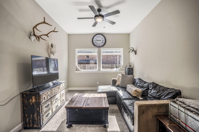 living room with baseboards, a ceiling fan, and carpet floors