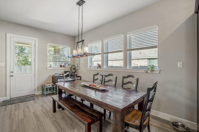 dining space featuring baseboards, a chandelier, and plenty of natural light