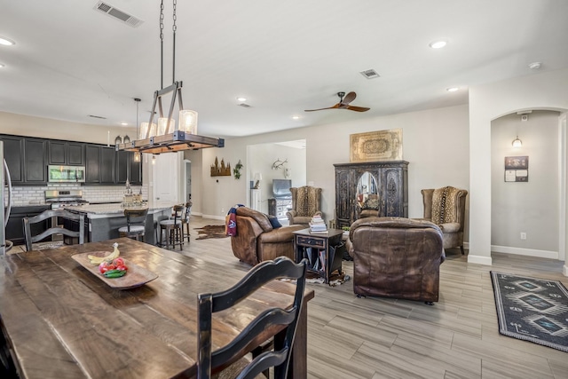 dining space with arched walkways, baseboards, and visible vents