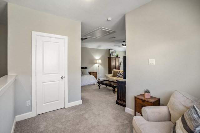 living area with ceiling fan, carpet, baseboards, and attic access