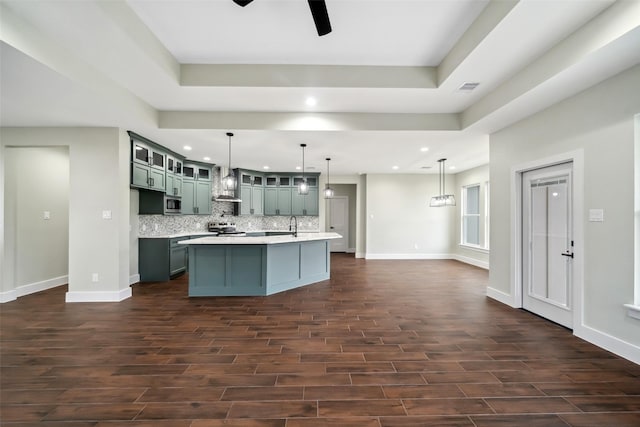 443 Wellshire Dr, West Columbia, TX 77486 - kitchen with wall chimney exhaust hood, dark wood finished floors, ceiling fan, light countertops, and tasteful backsplash