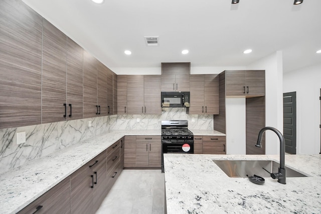 kitchen with black appliances, a sink, decorative backsplash, light stone counters, and recessed lighting
