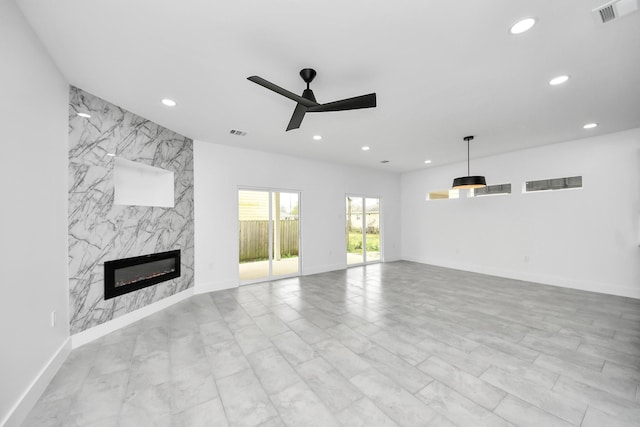 unfurnished living room with recessed lighting, a ceiling fan, a high end fireplace, and baseboards