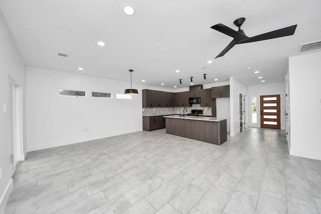kitchen with black microwave, recessed lighting, modern cabinets, decorative backsplash, and light countertops