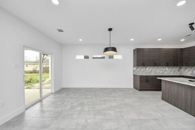 kitchen with light countertops, recessed lighting, dark brown cabinetry, baseboards, and decorative light fixtures