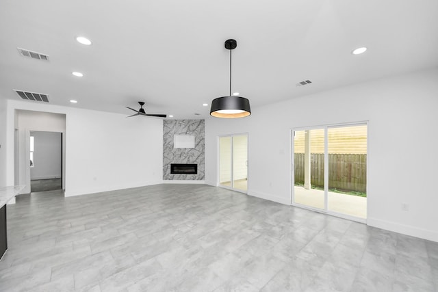 unfurnished living room with ceiling fan, recessed lighting, a fireplace, and baseboards