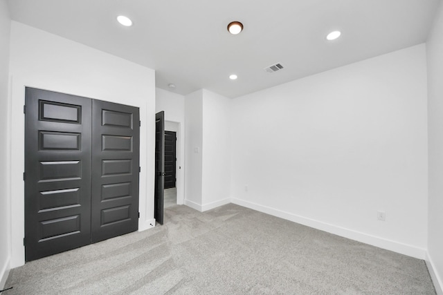 unfurnished bedroom featuring carpet, baseboards, recessed lighting, and a closet
