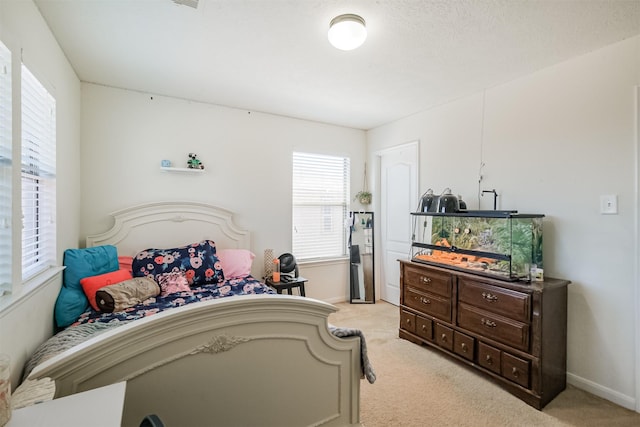 bedroom with baseboards, multiple windows, and light carpet