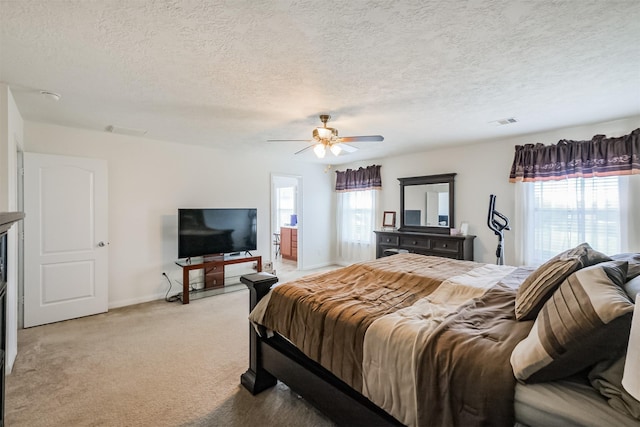 bedroom with multiple windows, a textured ceiling, visible vents, and light carpet