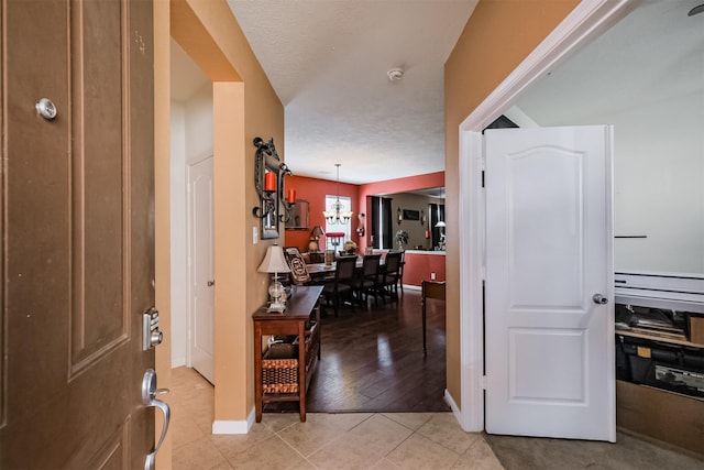 entrance foyer with an inviting chandelier, baseboards, and light tile patterned floors