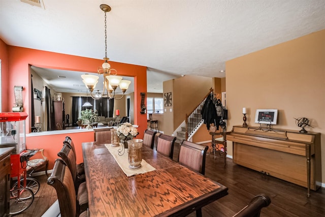 dining room with stairs, wood finished floors, visible vents, a chandelier, and baseboards