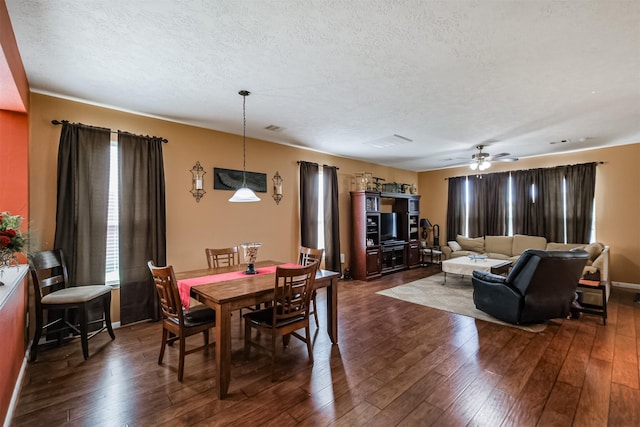 dining room with a ceiling fan, dark wood-style flooring, and a textured ceiling