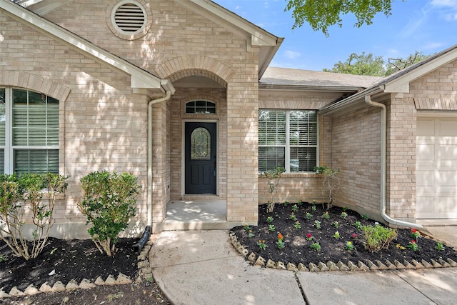 property entrance with brick siding and a garage
