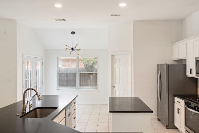 kitchen with a kitchen island, dark countertops, visible vents, and a sink