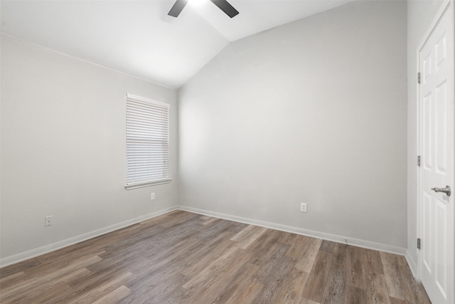 empty room featuring wood finished floors, baseboards, lofted ceiling, and a ceiling fan