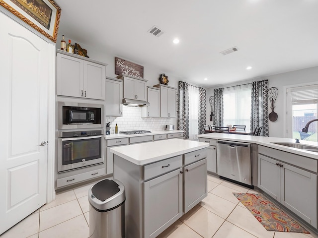 kitchen featuring stainless steel appliances, gray cabinetry, visible vents, a sink, and light countertops