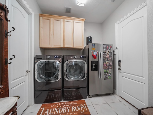 laundry room with light tile patterned floors, independent washer and dryer, visible vents, and cabinet space