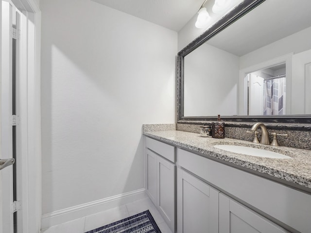 full bath with vanity, baseboards, and tile patterned flooring