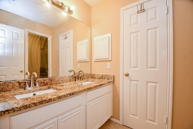bathroom featuring a sink, double vanity, baseboards, and tile patterned floors