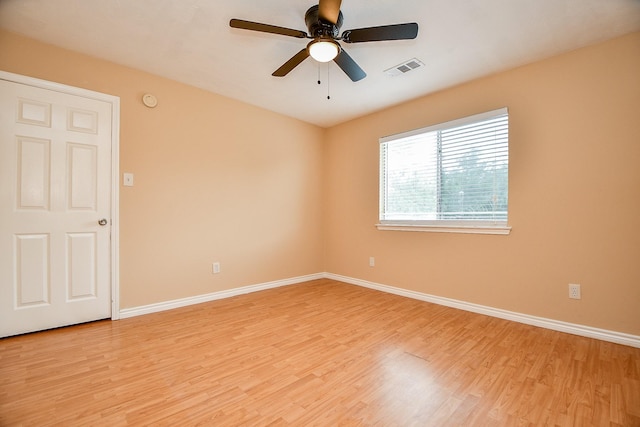 empty room featuring light wood-style floors, visible vents, baseboards, and ceiling fan