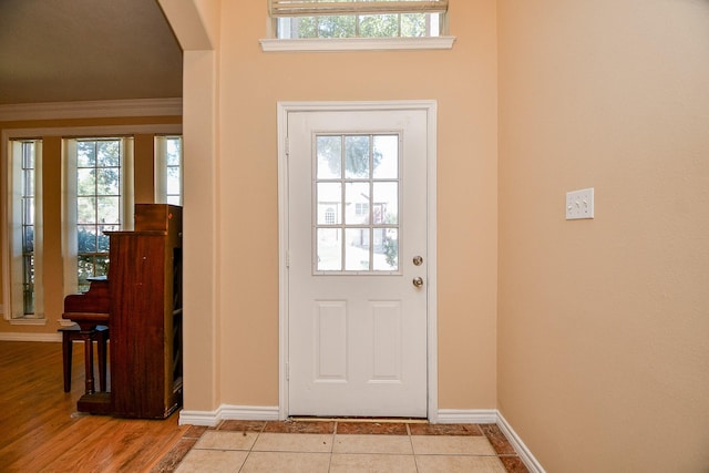 doorway to outside featuring a wealth of natural light, arched walkways, and baseboards