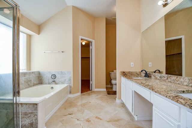 bathroom featuring toilet, a sink, a garden tub, double vanity, and a walk in closet