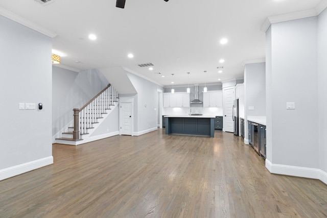 unfurnished living room featuring baseboards, stairs, ornamental molding, and visible vents