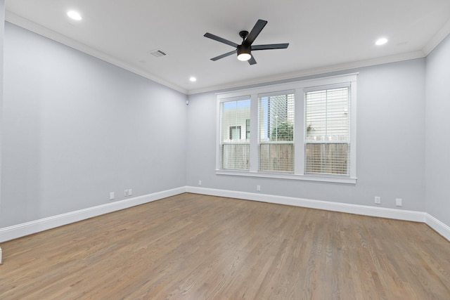 unfurnished room with wood finished floors, ornamental molding, visible vents, ceiling fan, and baseboards