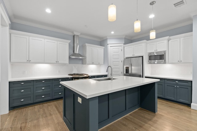 kitchen featuring a sink, visible vents, wall chimney exhaust hood, white cabinets, and appliances with stainless steel finishes