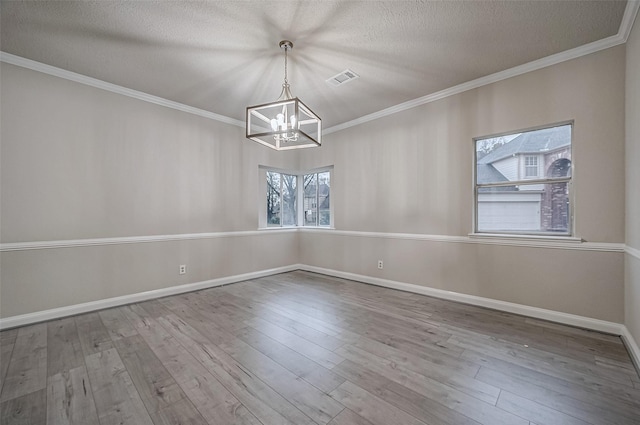 4218 Bayglen Ct, Houston, TX 77068 - unfurnished dining area with a notable chandelier, a textured ceiling, ornamental molding, visible vents, and wood finished floors