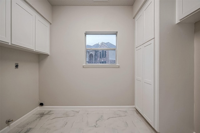 4218 Bayglen Ct, Houston, TX 77068 - clothes washing area with baseboards, marble finish floor, cabinet space, and electric dryer hookup
