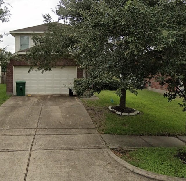 view of front of property featuring brick siding, driveway, and a front yard