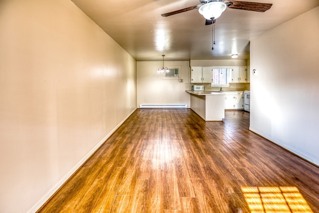 401 E Main St, Brenham, TX 77833 - unfurnished living room featuring baseboard heating, ceiling fan, dark wood-type flooring, and baseboards