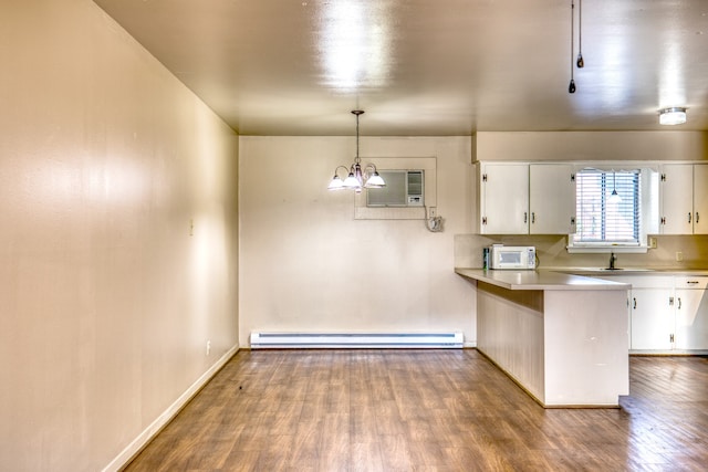 401 E Main St, Brenham, TX 77833 - kitchen with baseboard heating, white microwave, white cabinetry, and light countertops