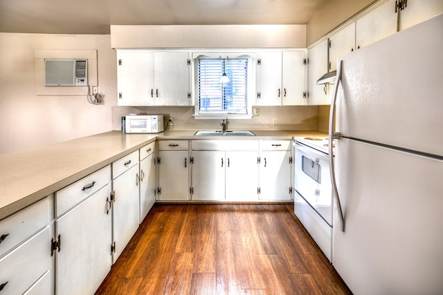 401 E Main St, Brenham, TX 77833 - kitchen with white appliances, a sink, dark wood-type flooring, light countertops, and under cabinet range hood