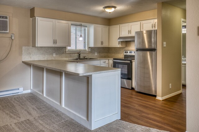 401 E Main St, Brenham, TX 77833 - kitchen with appliances with stainless steel finishes, baseboard heating, a peninsula, and white cabinetry