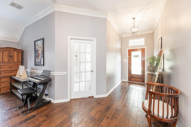 foyer with baseboards, visible vents, crown molding, dark wood-style floors, and a notable chandelier