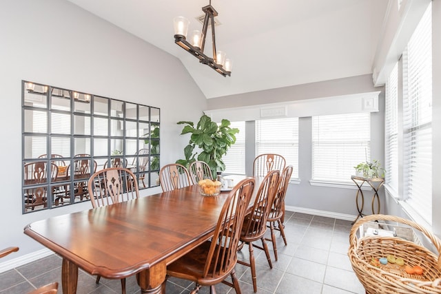 tiled dining space with vaulted ceiling and baseboards