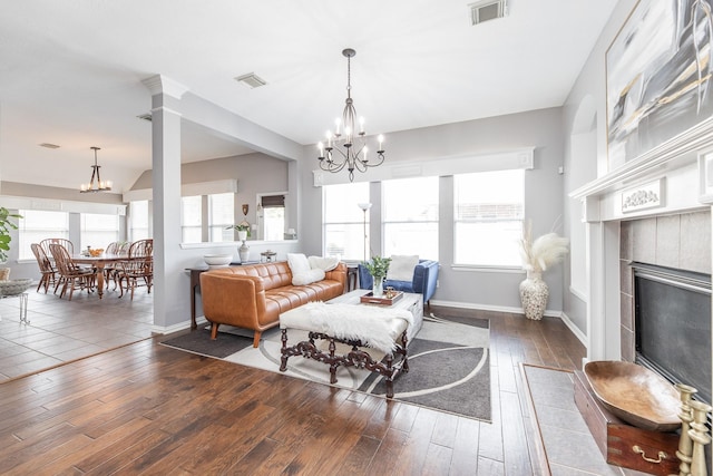 living room featuring an inviting chandelier, plenty of natural light, and visible vents