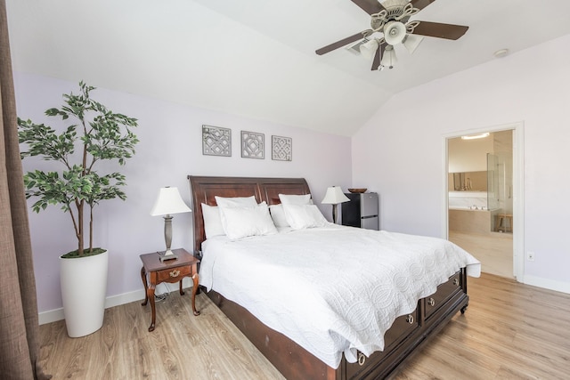 bedroom featuring lofted ceiling, light wood-style floors, ensuite bath, and baseboards