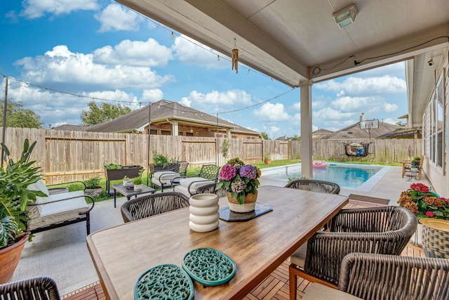 view of patio / terrace featuring an outdoor hangout area, outdoor dining area, a fenced in pool, and a fenced backyard