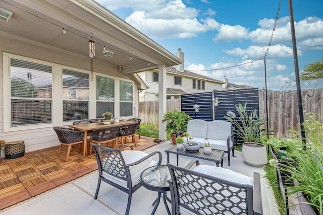view of patio with a fenced backyard, an outdoor hangout area, outdoor dining area, and visible vents